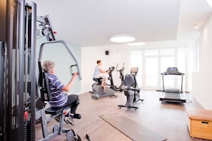 A gym with exercise equipment, a treadmill, and a large window. - Apartment Sonnentraum Südkap-Pelzerhaken - App. Sonnentraum, 62m², terrace, up to 3 (Neustadt in Holstein)