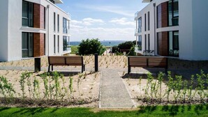 Un edificio moderno con un percorso centrale, panchine e vista sul mare.