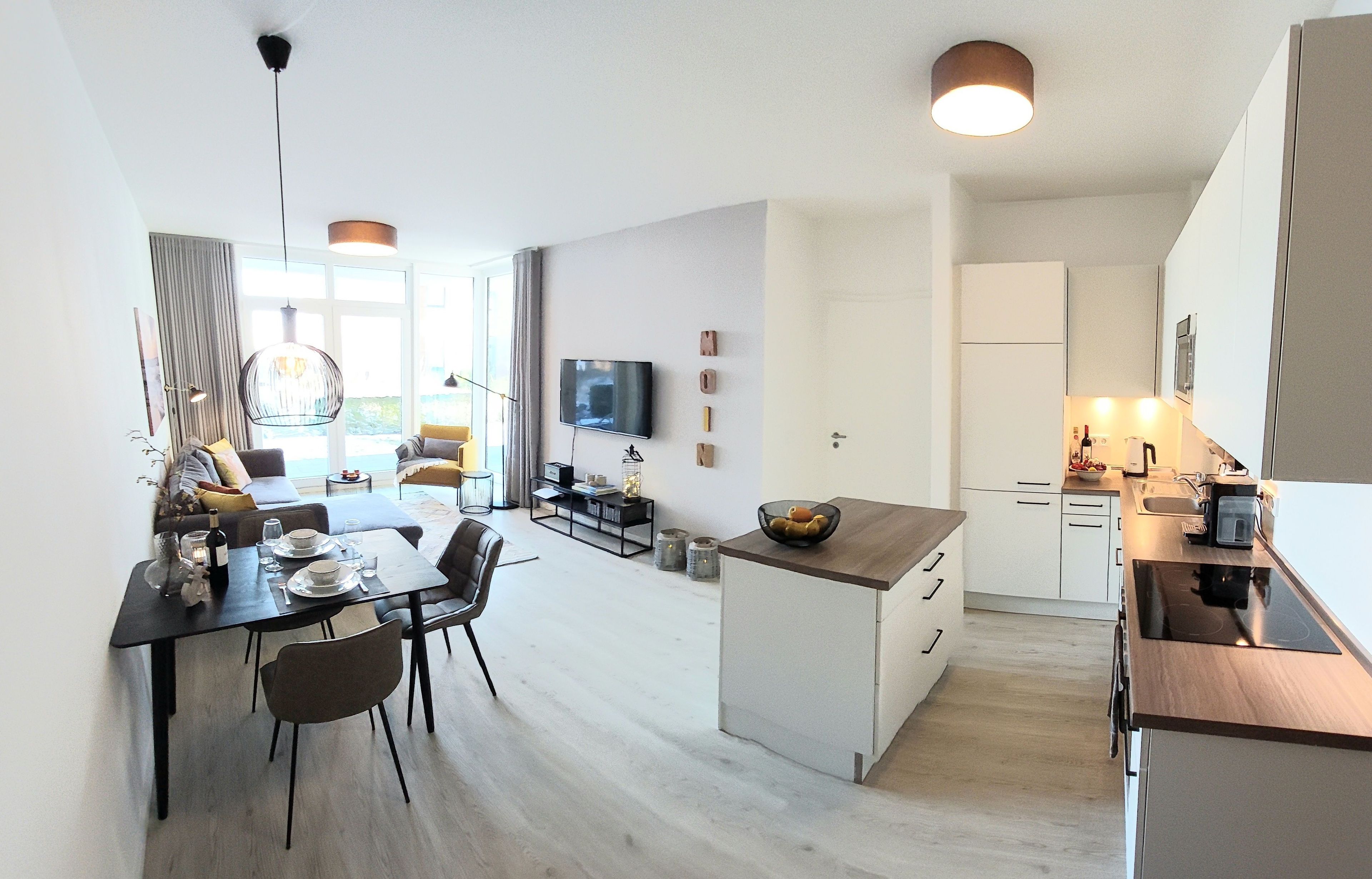 En moderne lejlighed med spiseplads, køkken og opholdsstue.