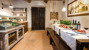 A rustic dining area with a buffet setup, wooden beams, and a traditional door. - Podere San Gregorio (Pienza)