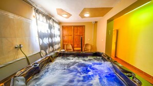 Un jacuzzi con una puerta de madera y sillas de mimbre al fondo.