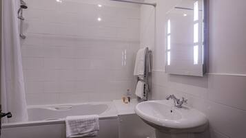 A modern bathroom with a bathtub, a sink, and a mirror.