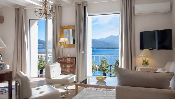 Et hotelværelse med balkon, lysekrone, fladskærms-tv og havudsigt.