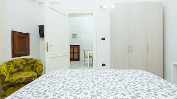 Un dormitorio con cama, armario, silla y puerta que da a otra habitación.