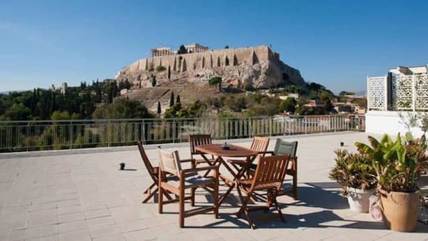 A terrace with outdoor furniture and a view of a historic building. - New Acropolis Museum Flat (Athens)