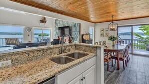 A kitchen with granite countertops, a stone backsplash, and a large window overlooking a scenic view.