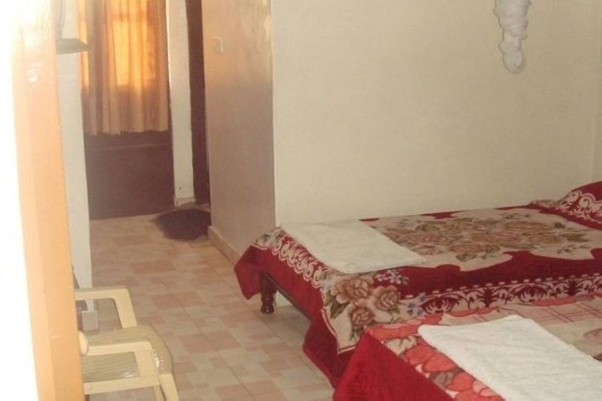 Ein Schlafzimmer mit einem Bett, einem Sessel und einer Tür zu einem weiteren Raum.