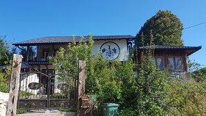 A traditional wooden house with a stone staircase leading to a gated entrance. - Apartments Una Riverlodge (Bihac)