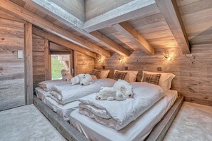 A wooden cabin bedroom with two beds, each with white bedding and teddy bears. - CHALET GRAND PARADIS, comfort, refinement, 7 bedrooms, cinema, SPA, near center (Megève)