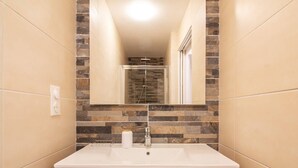 A bathroom with a white sink, a wooden vanity, and a mirror. - Central apartment for 4-9 people with parking in Cauterets (Cauterets)