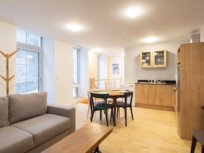 Um apartamento moderno com sala de estar, espaço para refeições e cozinha.