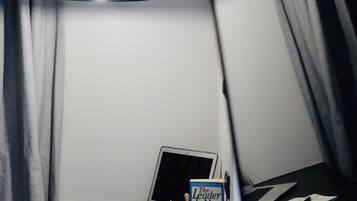 A room with a hanging pendant light, a laptop, and a book titled "The Leader".