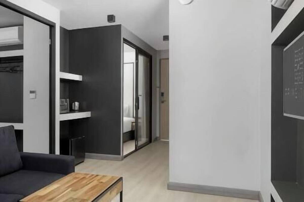A modern interior with a sofa, a wooden coffee table, and a walk-in closet.