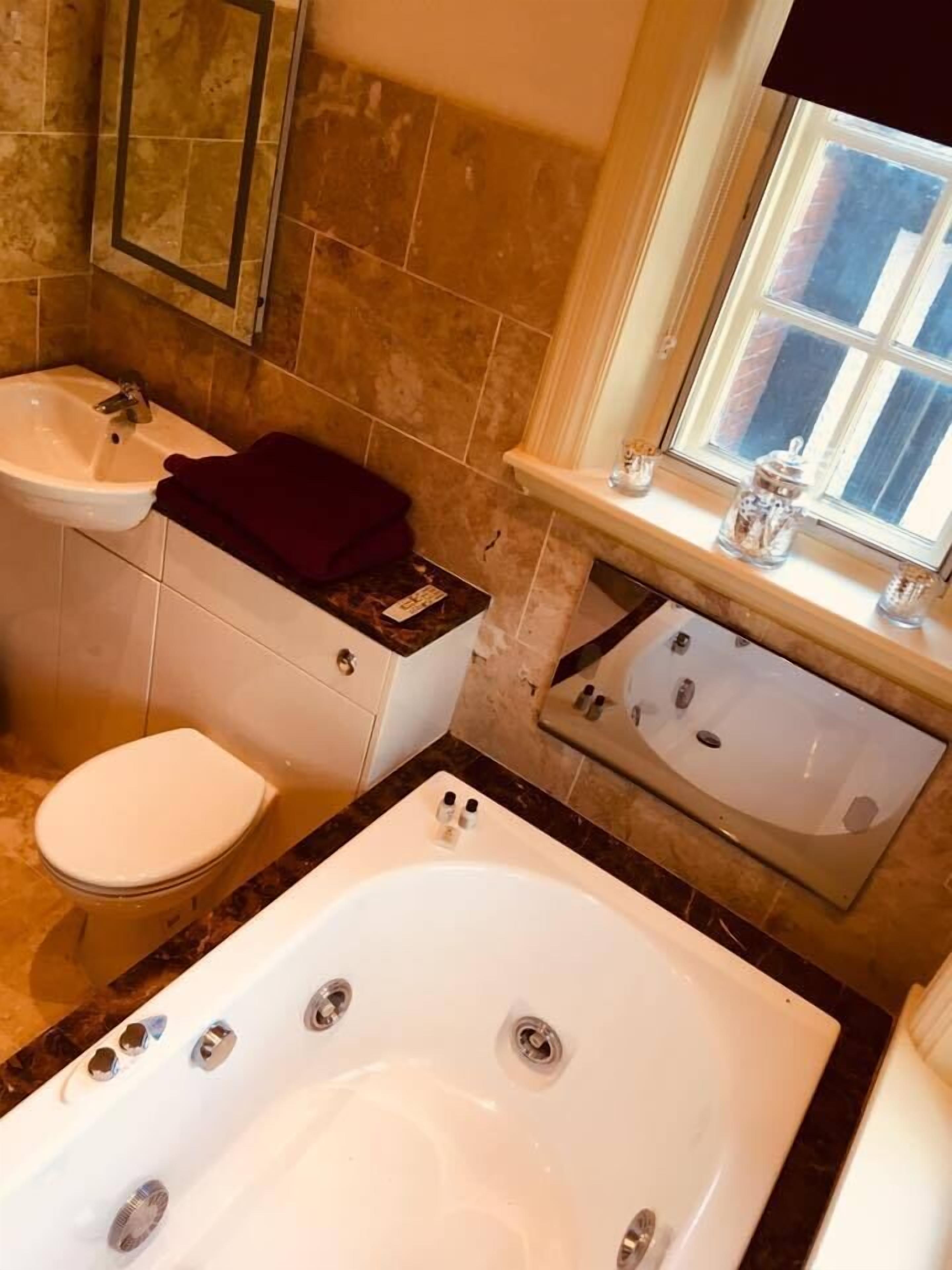 A bathroom with a bathtub, a toilet, and a sink.