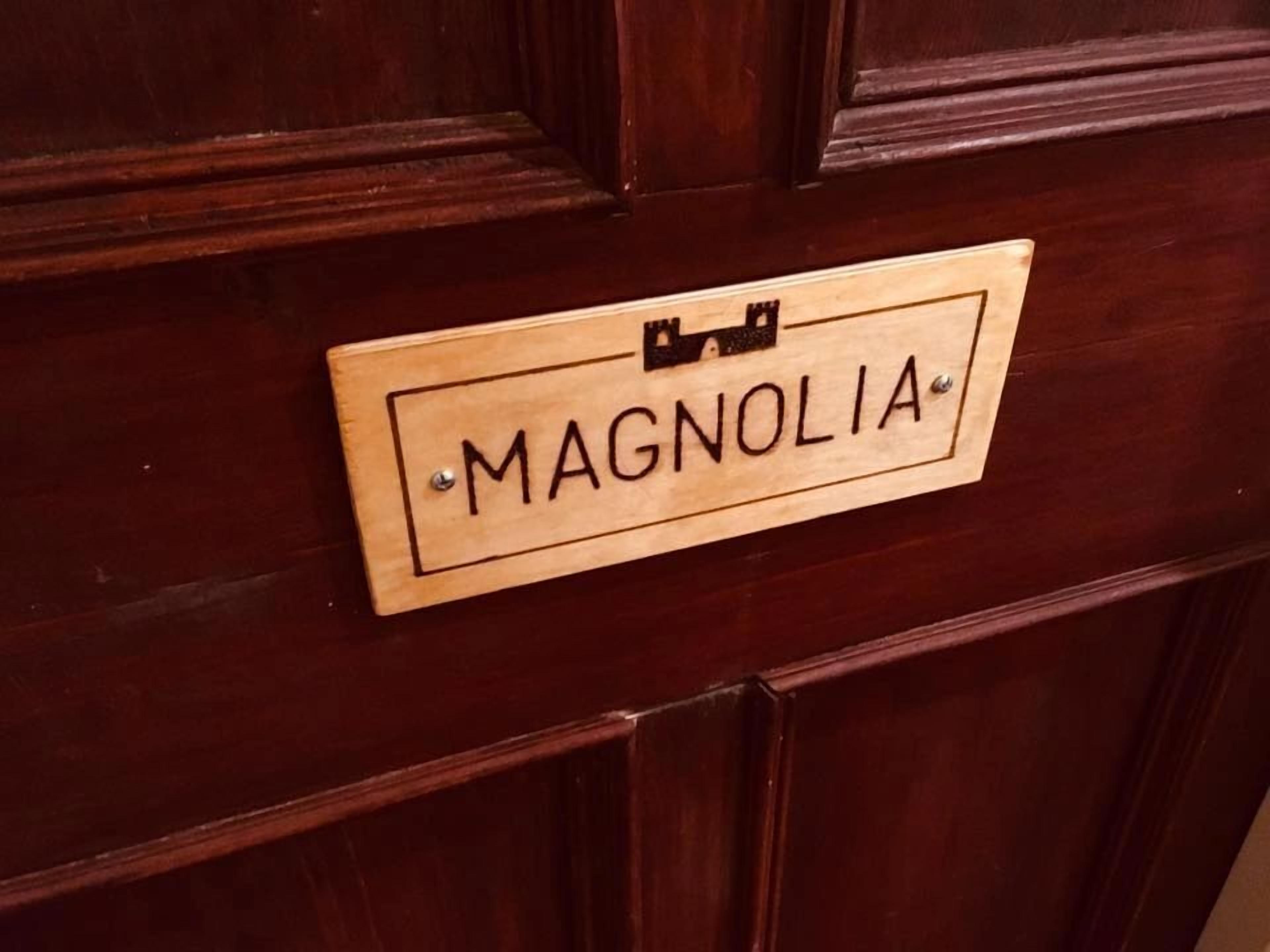 A wooden door with a nameplate that reads "MAGNOLIA."