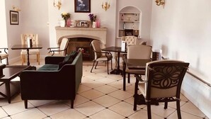 A spacious living room with a fireplace, a dining area, and a seating arrangement including a sofa and chairs. - Brass Castle Country House Accommodation (Middlesbrough)
