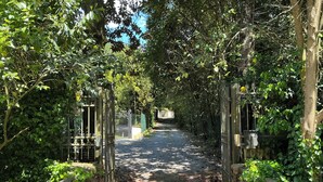 A pathway flanked by metal gates and lush greenery, leading to a building. - Spacious & Bright in Lucca Country Villa  (Capannori, Lucca, Tuscany)