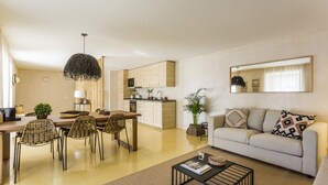 Een moderne woonkamer met een bank, salontafel en eethoek.