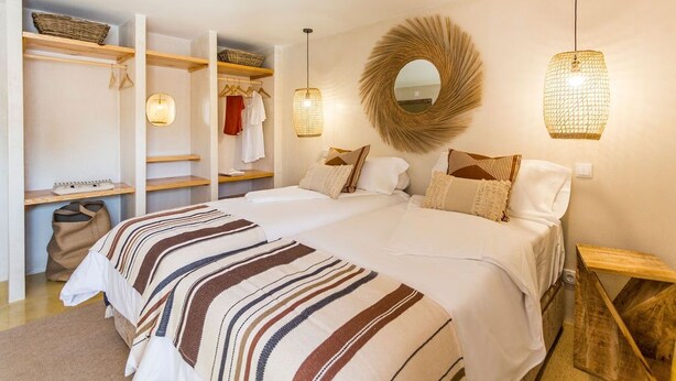 Een slaapkamer met een groot bed, een kledingkast en een spiegel.