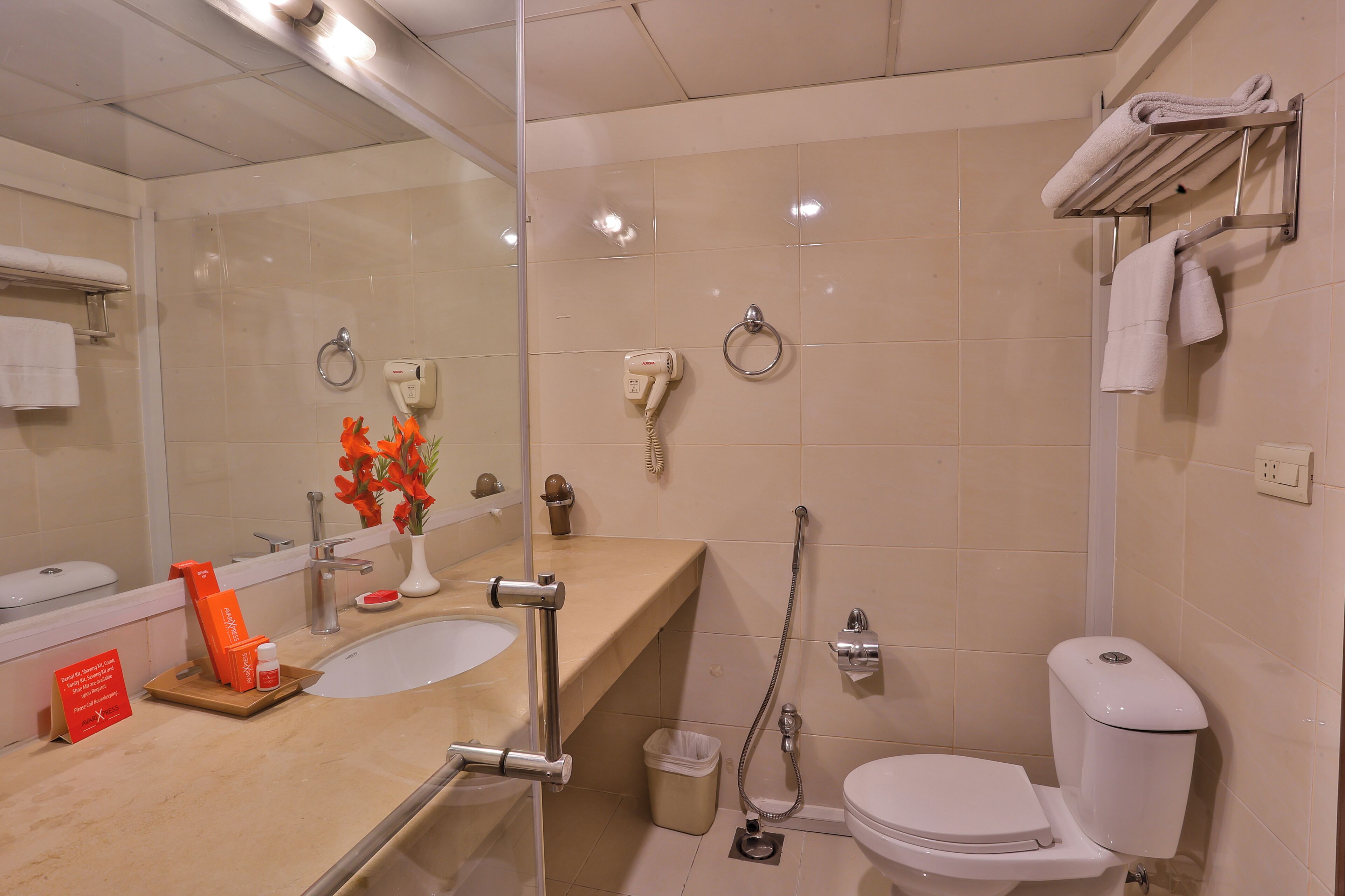 A modern bathroom with a glass shower enclosure, a sink with a vanity, a toilet, and a towel rack.