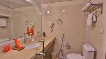 A modern bathroom with a glass shower enclosure, a sink with a vanity, a toilet, and a towel rack.