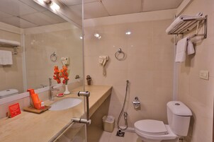 A modern bathroom with a glass shower enclosure, a sink with a vanity, a toilet, and a towel rack.
