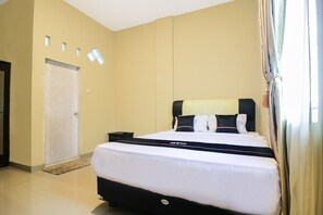 Una camera d'albergo con un letto grande, un comodino e una porta con una finestra.