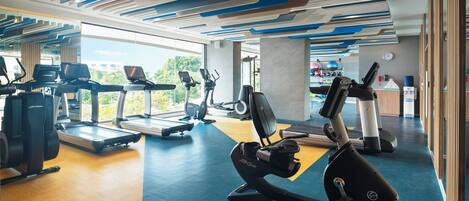 A gym with treadmills, elliptical machines, and weight equipment.