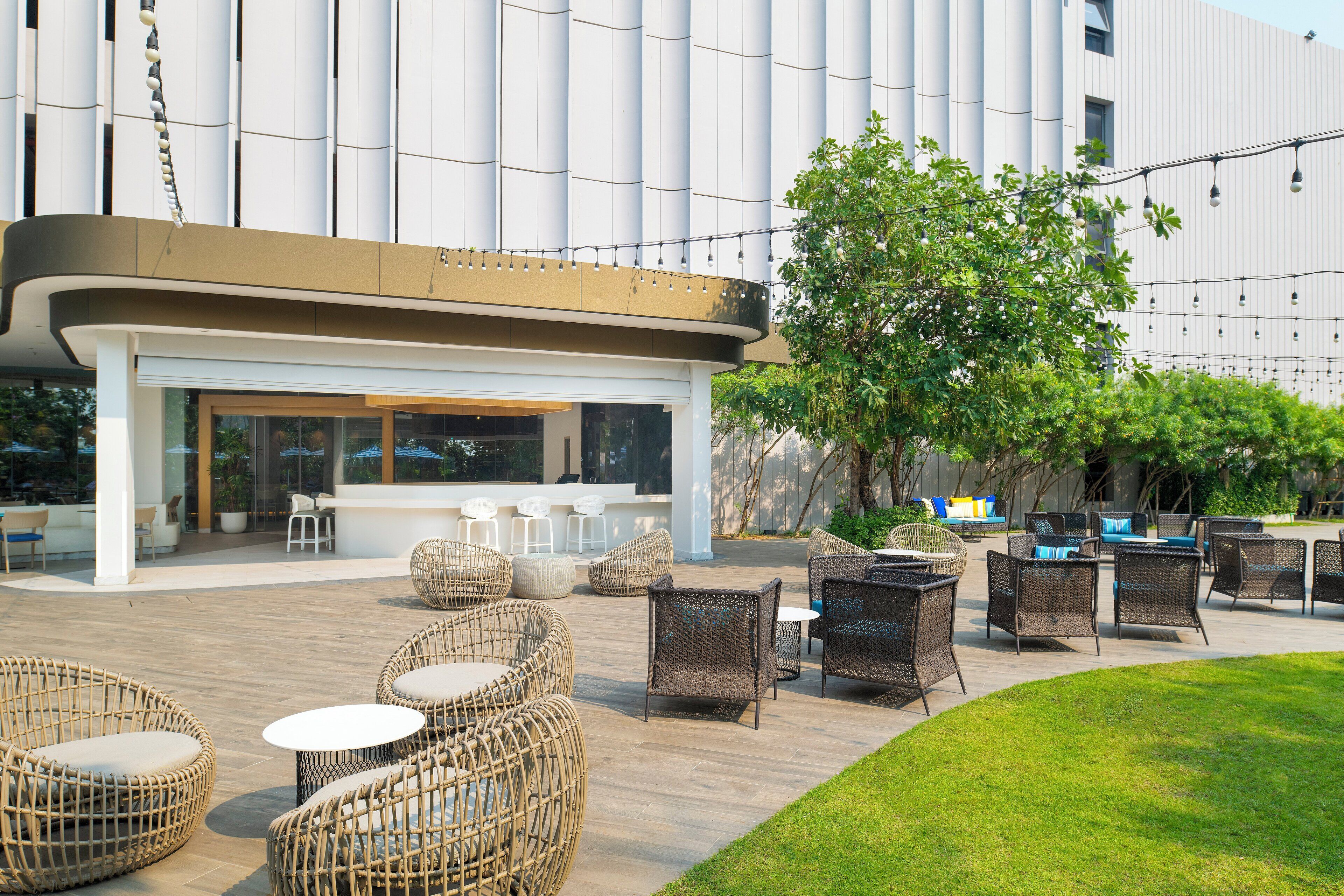 An outdoor seating area with wicker furniture and a bar.