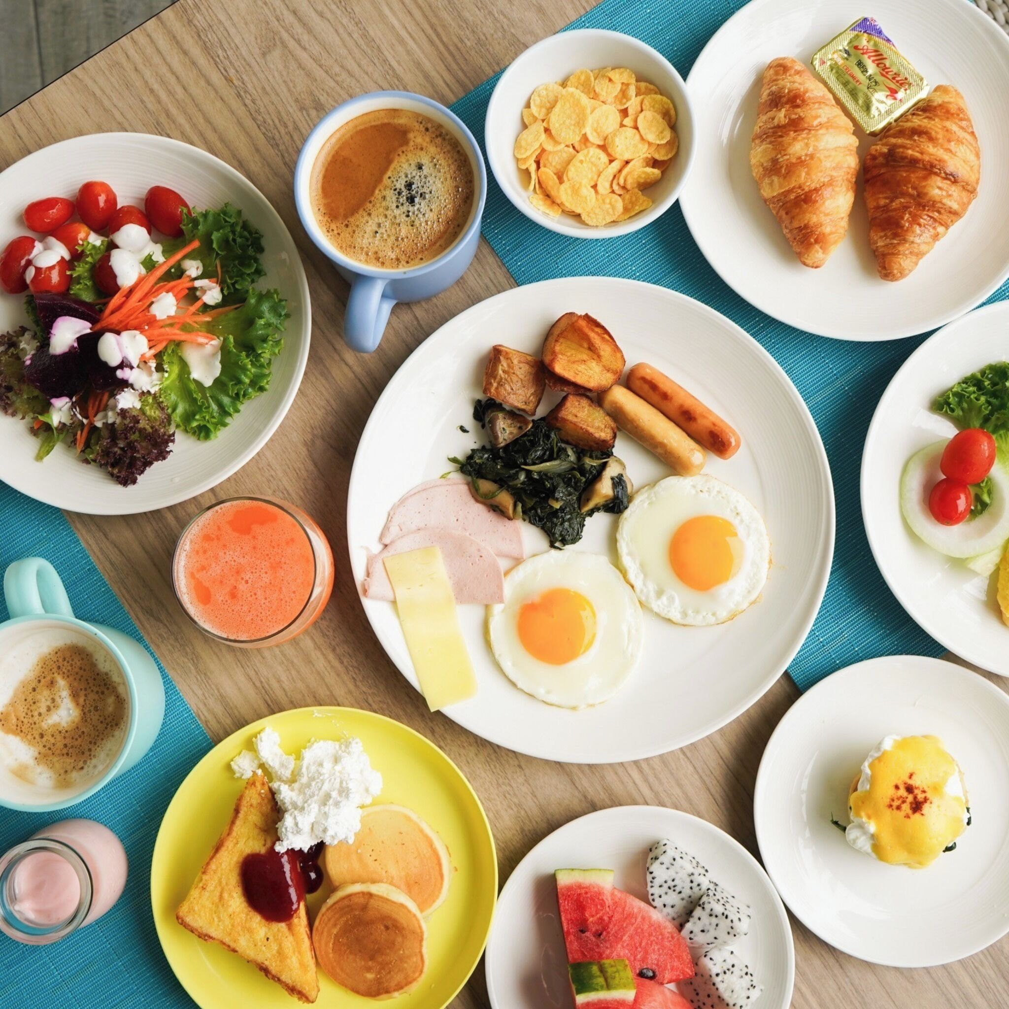 A breakfast spread with various dishes including eggs, toast, and a salad.