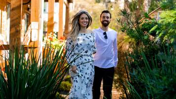 Una pareja caminando por un sendero de ladrillo frente a un edificio con un letrero que dice 'Chale Suico'.