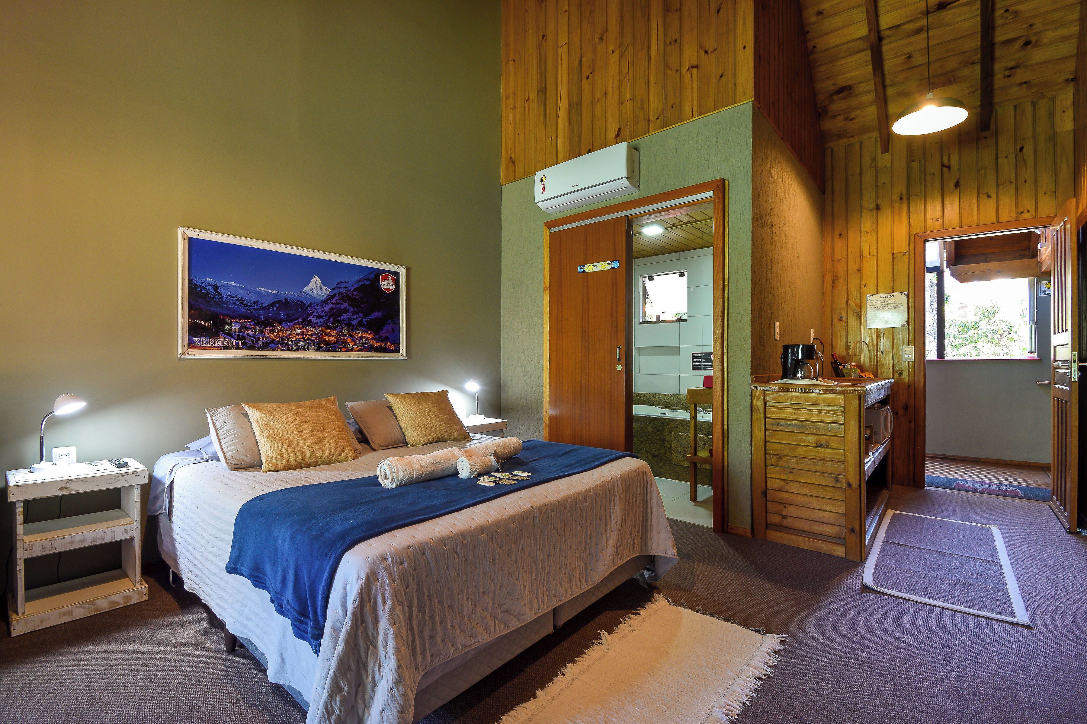 Un dormitorio con cama, mesitas de noche, un espejo y vistas a un paisaje montañoso.