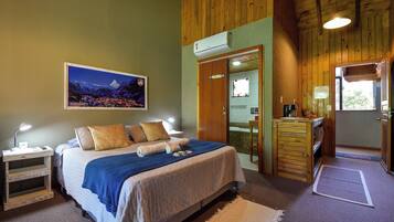 Un dormitorio con cama, mesitas de noche, un espejo y vistas a un paisaje montañoso.