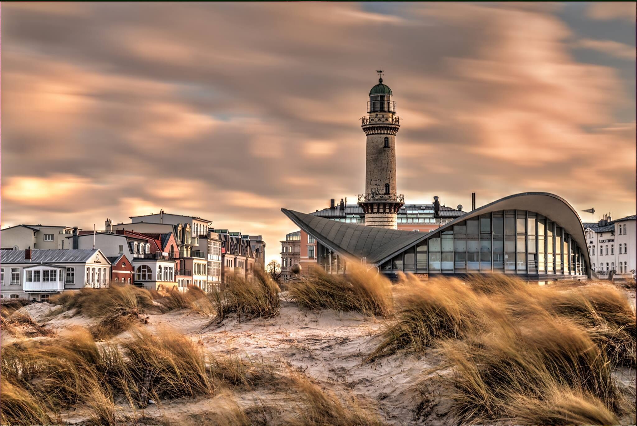 A coastal town with a prominent lighthouse and modern architecture.