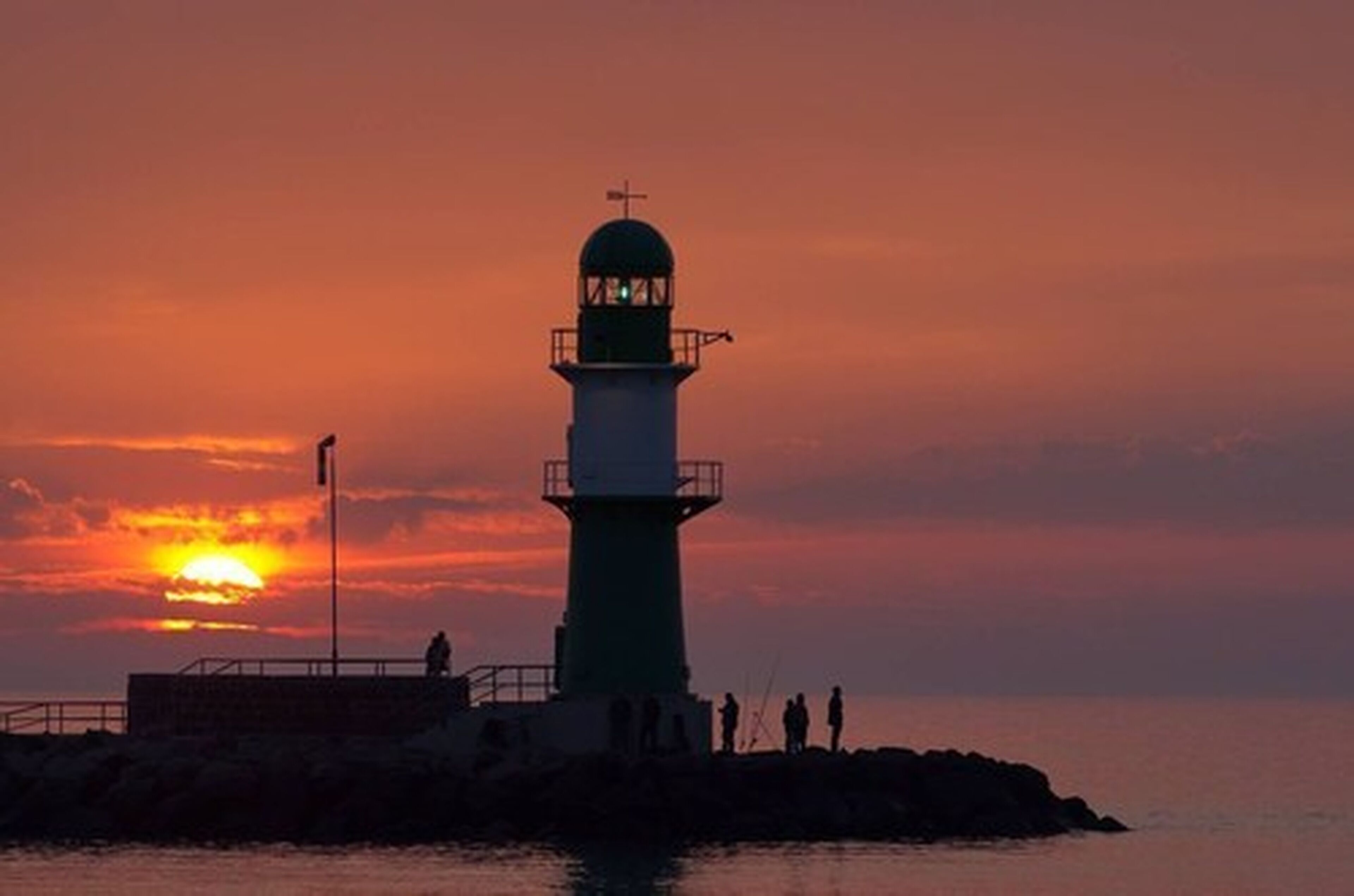 Un phare au coucher du soleil, avec un ciel dégagé.