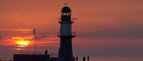 Un phare au coucher du soleil, avec un ciel dégagé.
