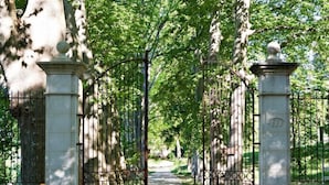 A gated entrance with a pathway leading into a park area. - Chateau Mentone (Saint-Antonin-du-Var)