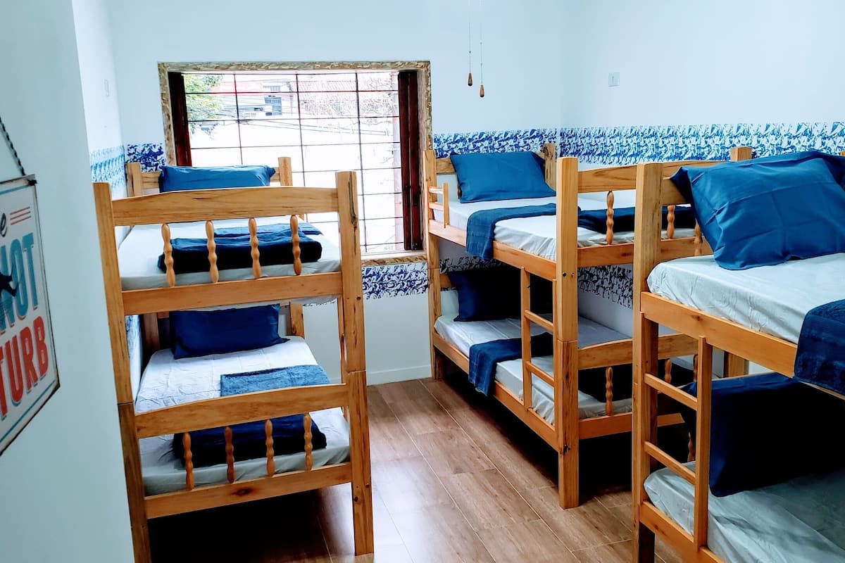 A dormitory room with bunk beds, a window, and a 'Please DO NOT STURB' sign.