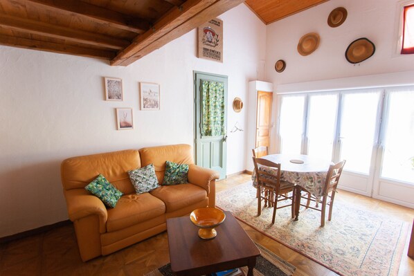 A cozy living room with a sofa, a coffee table, and a dining area with a table and chairs.