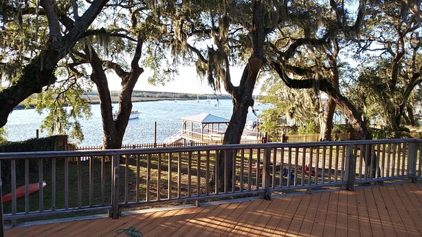 A wooden deck with a railing overlooking a body of water, a gazebo, and trees with hanging moss. - Peaches and Beaches.... come eat some fresh peaches, close to the island beaches (Saint Marys)