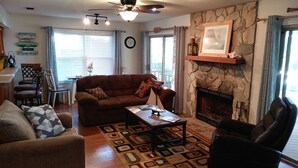 A living room with a brown sofa, a coffee table, a fireplace, and a stone wall. - Peaches and Beaches.... come eat some fresh peaches, close to the island beaches (Saint Marys)