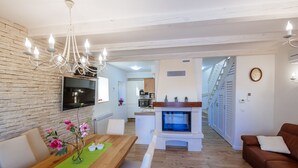 Ein modernes Wohnzimmer mit einem Holzespeisetisch, einem Kamin, einem braunen Ledersofa und einer Kandelaber.