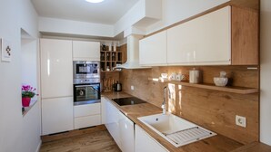 Eine moderne Küche mit weißen Schränken, einer Holz Arbeitsplatte und einem Edelstahlbackofen.