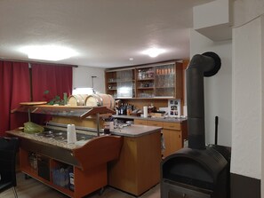 Une cuisine équipée d’une cuisinière intégrée, de meubles en bois et d’un plan de travail sur lequel sont disposés divers objets.