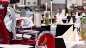 Un restaurant doté d’une trancheuse à viande rouge, de nappes blanches et d’un ananas posé sur la table.