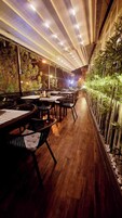 Un restaurante interior con suelo de madera, mesas y sillas.