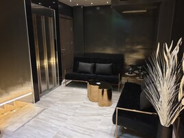 Un interior moderno con un sofá oscuro, una mesa de centro redonda y un jarrón decorativo.