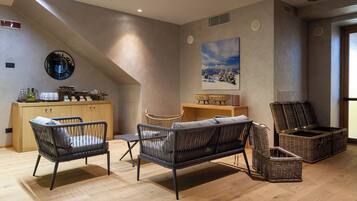 A modern living room with a wooden cabinet, wicker furniture, and a painting of a snowy landscape.