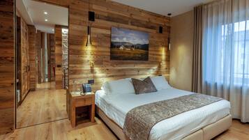 Un dormitorio con pared de madera, una cama, una mesita de noche, un cuadro y una ventana con cortinas.