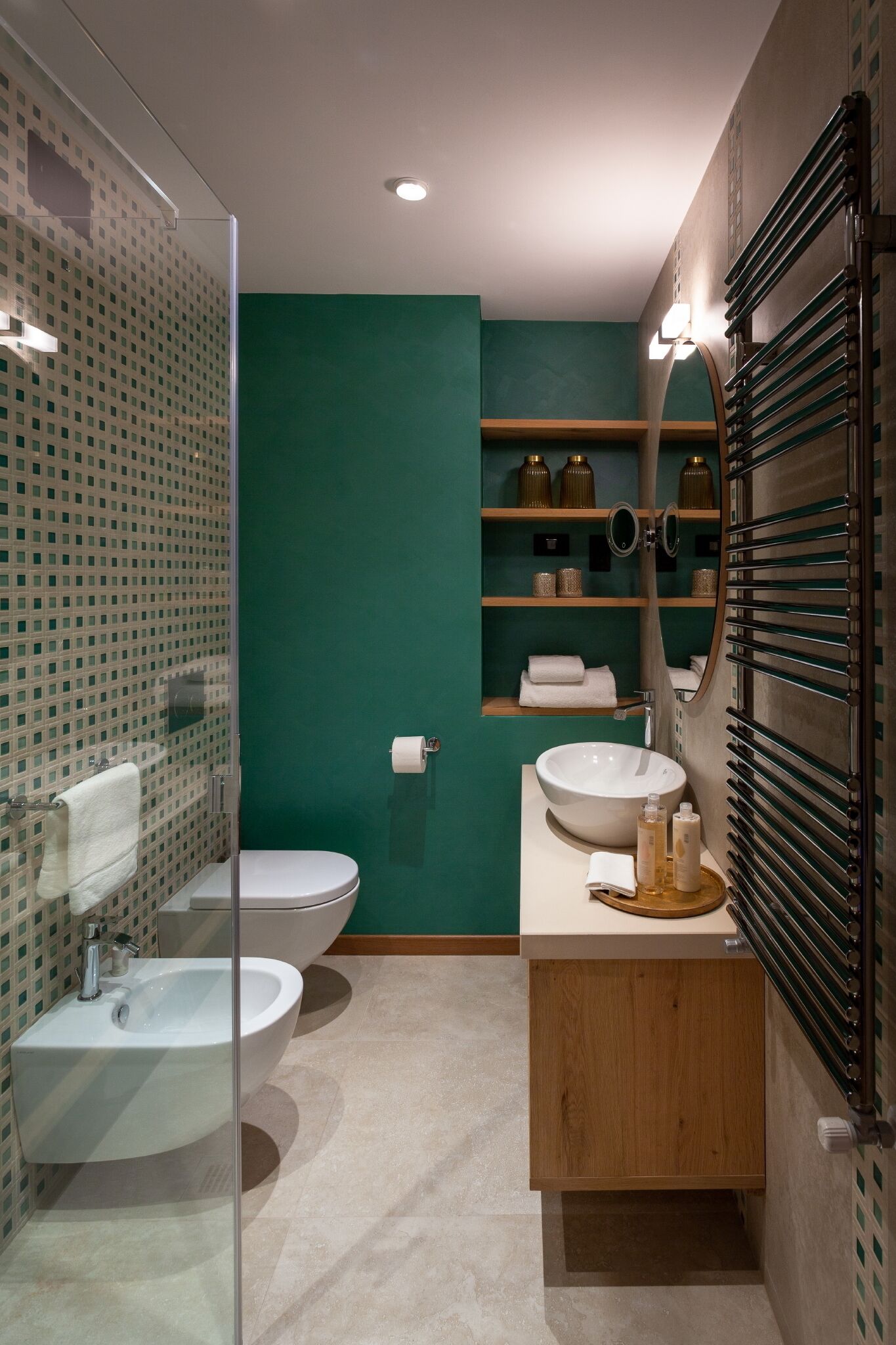 A modern bathroom with a glass shower enclosure, a white sink, and a vanity with a mirror.